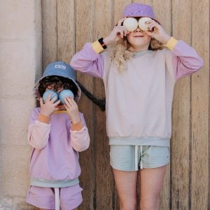 Deux enfants en tenue Marmaï Patterns tenant des boules de petanque devant leurs yeux